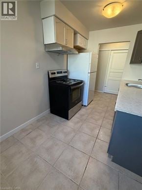 Waterloo apartment for rent - A kitchen with a black stove top oven and a white refrigerator.