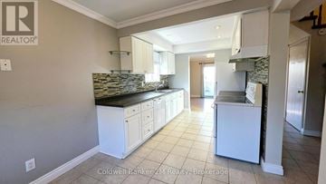 Oshawa (Pinecrest) apartment for rent - A kitchen with white cabinets and a black countertop.