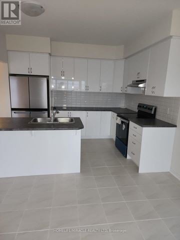 Brant (Paris) apartment for rent - A kitchen with white cabinets and a black countertop.