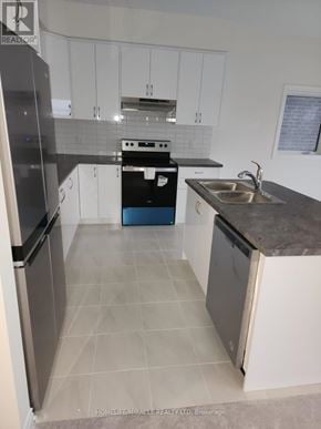 Brant (Paris) apartment for rent - A kitchen with white cabinets and a black fridge.