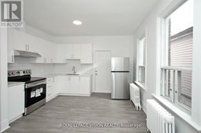 Toronto (Danforth Village-East York) apartment for rent - A white kitchen with a refrigerator, stove, and cabinets.