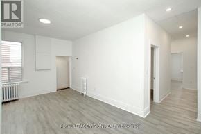 Toronto (Danforth Village-East York) apartment for rent - A white room with wood flooring and a window with blinds.