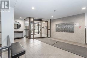 Guelph (Willow West/Sugarbush/West Acres) condo for rent - A white hallway with a glass door and a black bench.