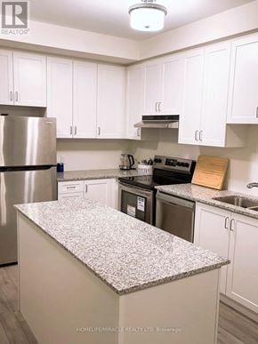Brampton (Northwest Brampton) condo for rent - A kitchen with white cabinets and a granite counter top.