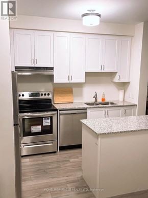 Brampton (Northwest Brampton) condo for rent - A kitchen with white cabinets and a granite counter top.