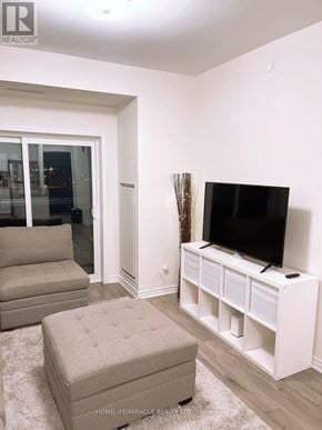 Brampton (Northwest Brampton) condo for rent - A living room with a flat screen TV on a white stand.