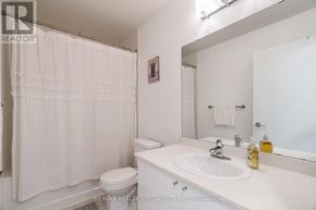 Mississauga (City Centre) condo for rent - A white bathroom with a toilet, sink, and shower curtain.