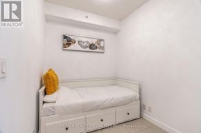 Mississauga (City Centre) condo for rent - A bedroom with a white bed and a yellow pillow.