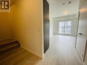 Mississauga (Erin Mills) townhouse for rent - A room with a wooden floor and a window with a view of buildings outside.