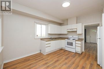 Niagara Falls (Downtown) apartment for rent - A kitchen with white cabinets and a wooden floor.