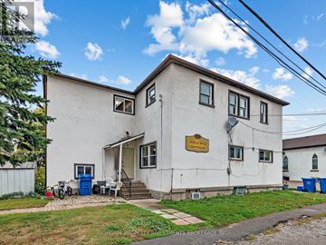 East Gwillimbury (Holland Landing) multi-family for rent - A white two-story building with a brown roof and a sign that reads "Hillcrest Property Investments Brokerage Inc." is shown.