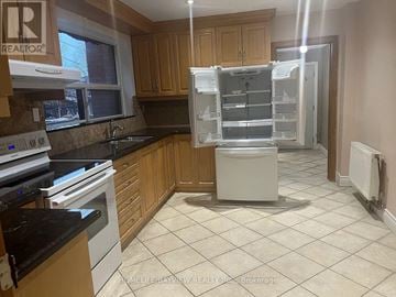 Toronto (Dovercourt-Wallace Emerson-Junction) apartment for rent - A kitchen with a white fridge and black countertops.