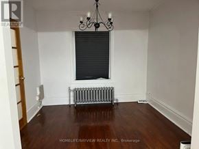 Toronto (Dovercourt-Wallace Emerson-Junction) apartment for rent - A room with a window, a radiator, and a chandelier.