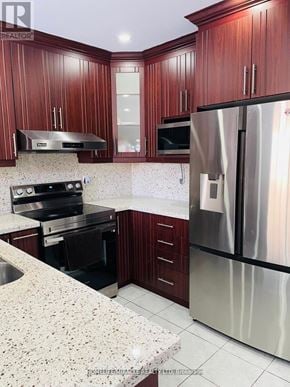 Brampton (Sandringham-Wellington) apartment for rent - A kitchen with wooden cabinets and a stainless steel refrigerator.