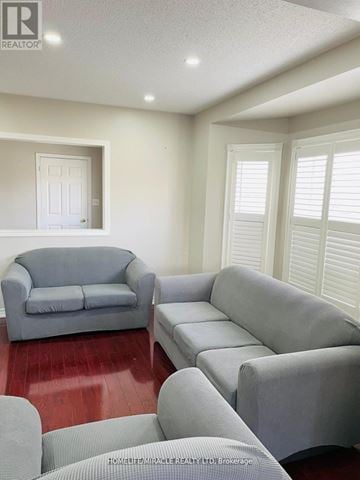 Brampton (Sandringham-Wellington) apartment for rent - A living room with grey couches and a wooden floor.