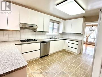 Toronto (Bayview Woods-Steeles) apartment for rent - A kitchen with white cabinets and a tiled floor.