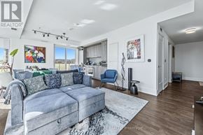 Toronto (Waterfront Communities) condo for rent - A living room with a grey couch and a white wall.
