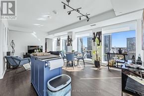 Toronto (Waterfront Communities) condo for rent - A living room with a blue sofa and a wooden coffee table.