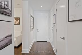 Toronto (Annex) condo for rent - A hallway with a white door and a white wall with a framed picture on it.