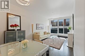Toronto (Annex) condo for rent - A modern living room with a glass table and a sofa.
