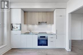 Toronto (Banbury-Don Mills) condo for rent - A modern kitchen with white cabinets and a blue oven.
