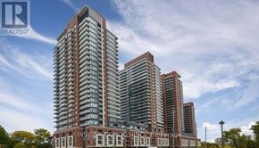 Toronto (Humber Heights) condo for rent - A tall residential building with a glass facade stands under a blue sky.