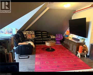 Waterloo condo for rent - A living room with a red carpet and a black leather sofa.