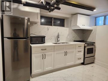 Toronto (Annex) multi-family for rent - A kitchen with white cabinets and a stainless steel refrigerator.
