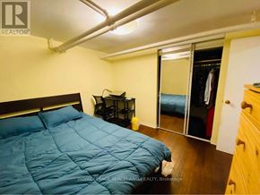 Toronto (Annex) multi-family for rent - A bedroom with a blue comforter and a sliding glass door.