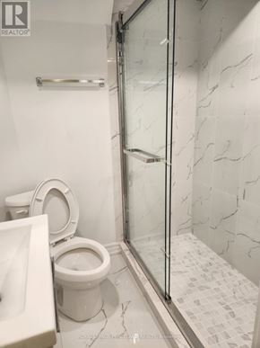 Toronto (Annex) multi-family for rent - A white toilet sits next to a sink in a bathroom.