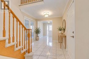 Brampton (Heart Lake West) apartment for rent - A hallway with a staircase and a table with a plant on it.