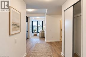 Kitchener condo for rent - A hallway with a rug on the floor and a painting on the wall.