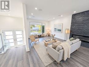 Oakville (Wo West) duplex for rent - A modern living room with a grey couch and a fireplace.