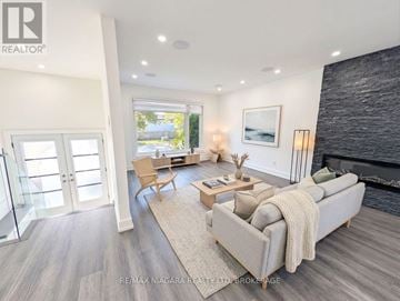 Oakville (Wo West) duplex for rent - A modern living room with a grey couch and a fireplace.