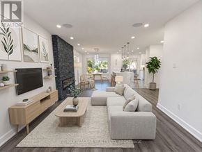 Oakville (Wo West) duplex for rent - A modern living room with a fireplace and a large grey sofa.