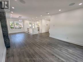 Oakville (Wo West) duplex for rent - A spacious room with wooden flooring and white walls.