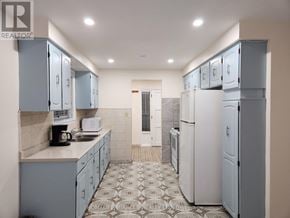 Toronto (Glenfield-Jane Heights) apartment for rent - A kitchen with white appliances and blue cabinets.