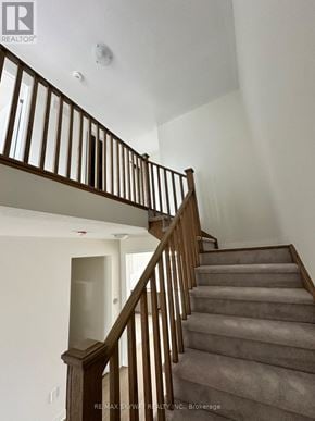 North Dumfries townhouse for rent - A staircase with a wooden railing and a carpeted runner.