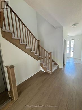 North Dumfries townhouse for rent - A wooden staircase with a white wall on the side.