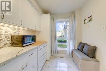 Toronto (Bayview Village) townhouse for rent - A kitchen with a microwave on the counter and a couch in the living area.