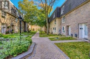 Toronto (Bayview Village) townhouse for rent - A brick pathway leads through a grassy area between two rows of houses.