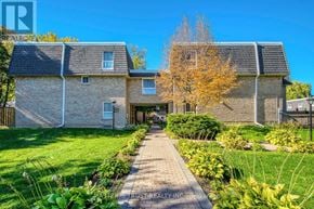 Toronto (Bayview Village) townhouse for rent - A house with a well-maintained lawn and a pathway leading to the front door.