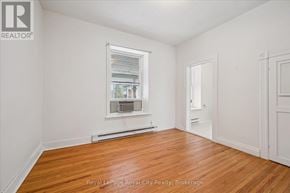 Centre Wellington (Elora/Salem) apartment for rent - A room with wooden floors and white walls, with a window and a door visible.