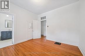 Centre Wellington (Elora/Salem) apartment for rent - A room with wooden floors and white walls, with a door to the right and a cabinet to the left.
