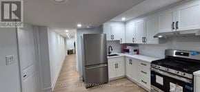 London South (South V) townhouse for rent - A kitchen with white cabinets and a stainless steel refrigerator.