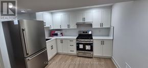 London South (South V) townhouse for rent - A kitchen with a stainless steel refrigerator and white cabinets.