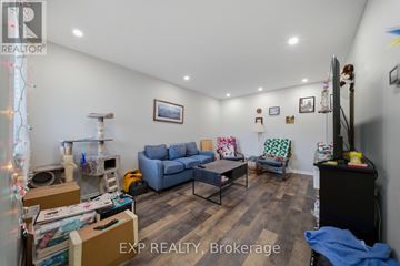 Ottawa townhouse for rent - A living room with a couch, chair, and a table with boxes on it.