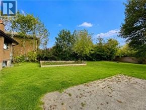 London apartment for rent - A backyard with a gravel area and a wooden fence.