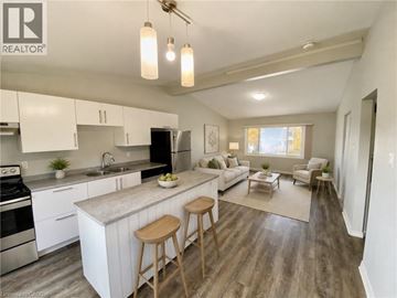 London apartment for rent - A well-lit kitchen with white cabinets and a wooden island.