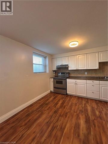 Hamilton apartment for rent - A kitchen with white cabinets and a wooden floor.